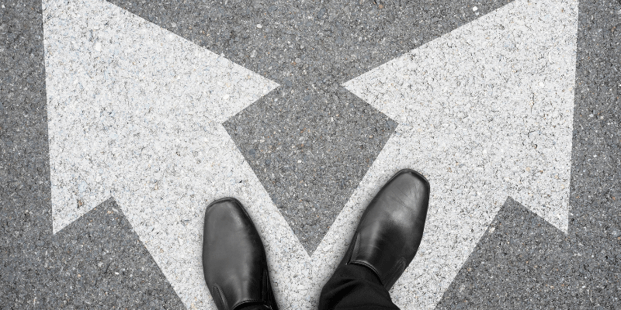 Feet standing on painted arrows pointing to different directions